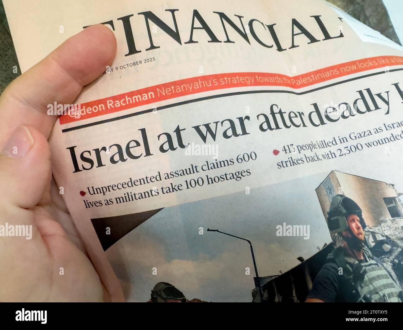 Paris, France - Oct 9, 2023: A male hand in a POV shot reads the headline: 'Israel at War After Unprecedented Assault - Gaza-Israel Conflict' from the Financial Times Stock Photo