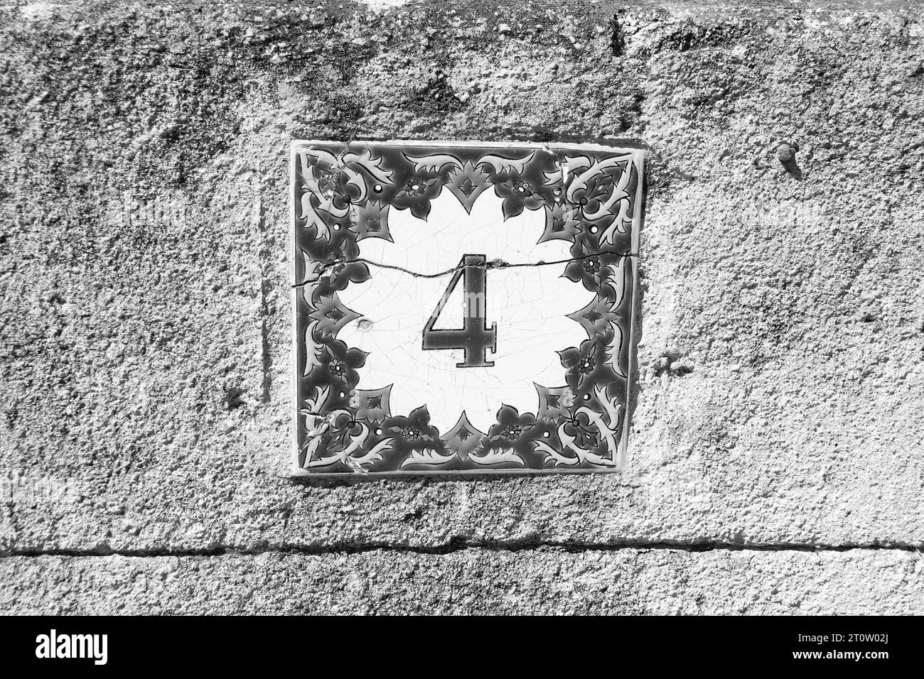 Greek style house number 4 (four) ceramic tile in black and white Stock Photo
