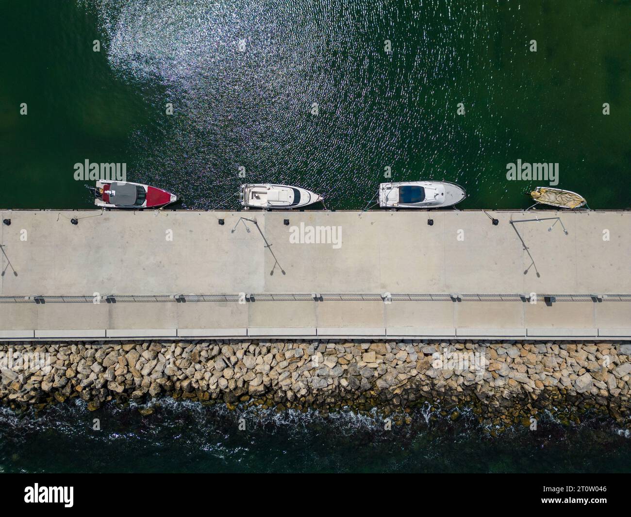 aerial top down view of a serene dock in the sea, with several fishing ...