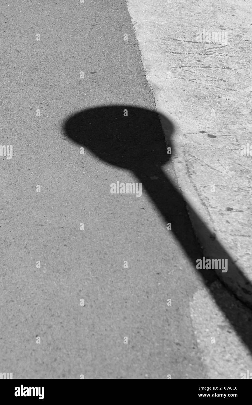 Street light post silhouette sun reflection on street ground Stock Photo