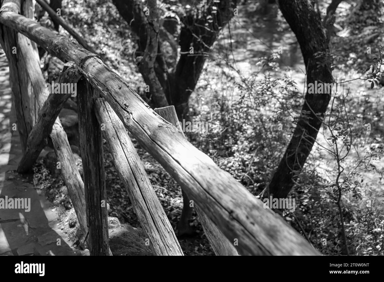 Black and white wooden safety rail located on the walking trail at Butterfly Valley, Rhodes, Greece Stock Photo