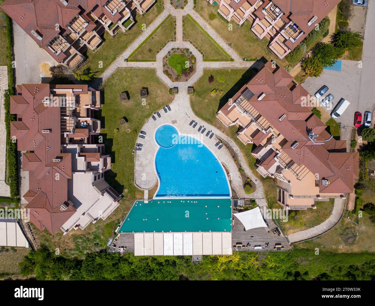 The massive modern hotel complex sprawled beneath, boasting a myriad of swimming pools, sports fields, and recreation areas. From above, the vibrant o Stock Photo