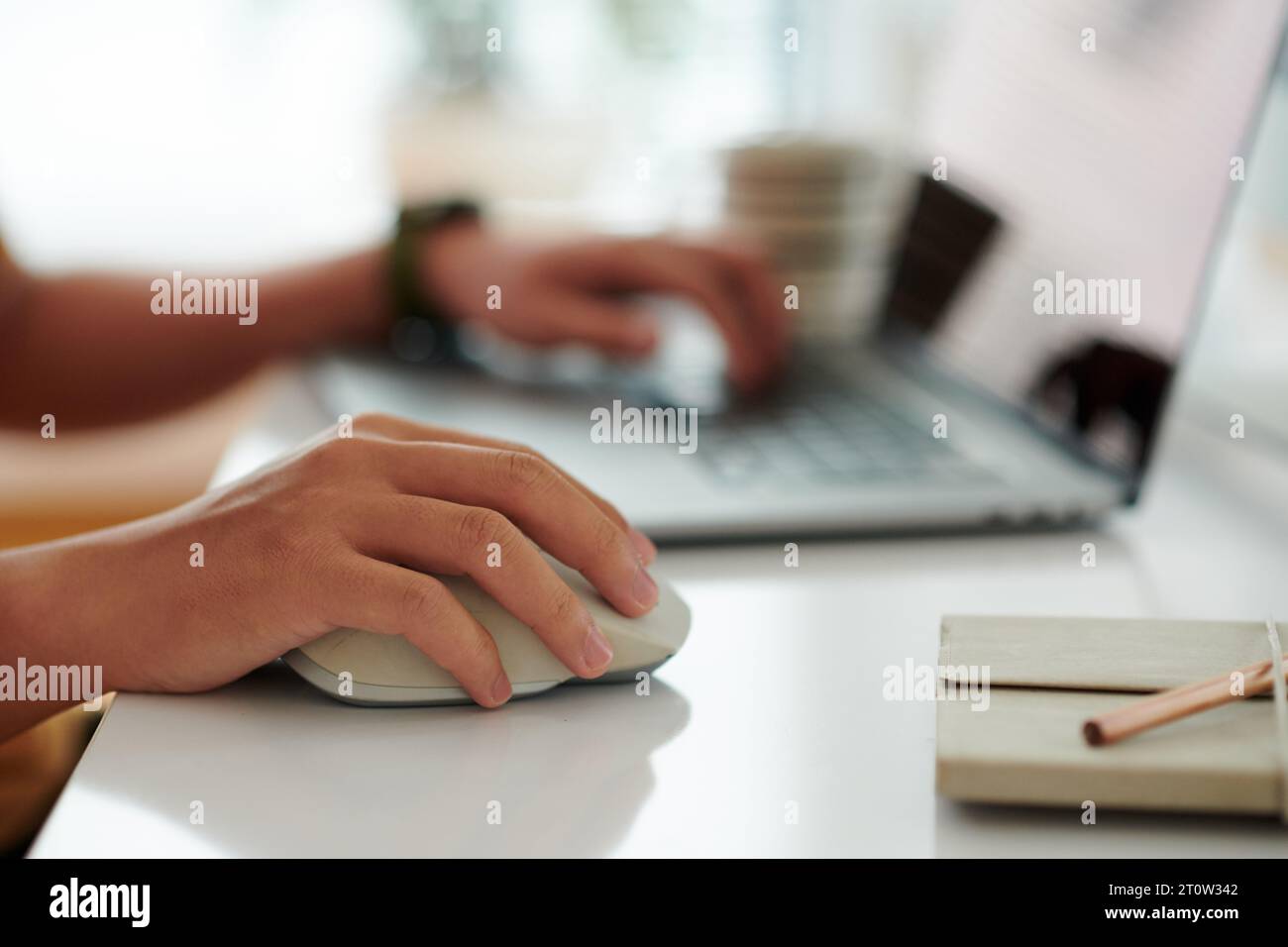 Closeup image of software developer working on computer, focus on hand with computer mouse Stock Photo