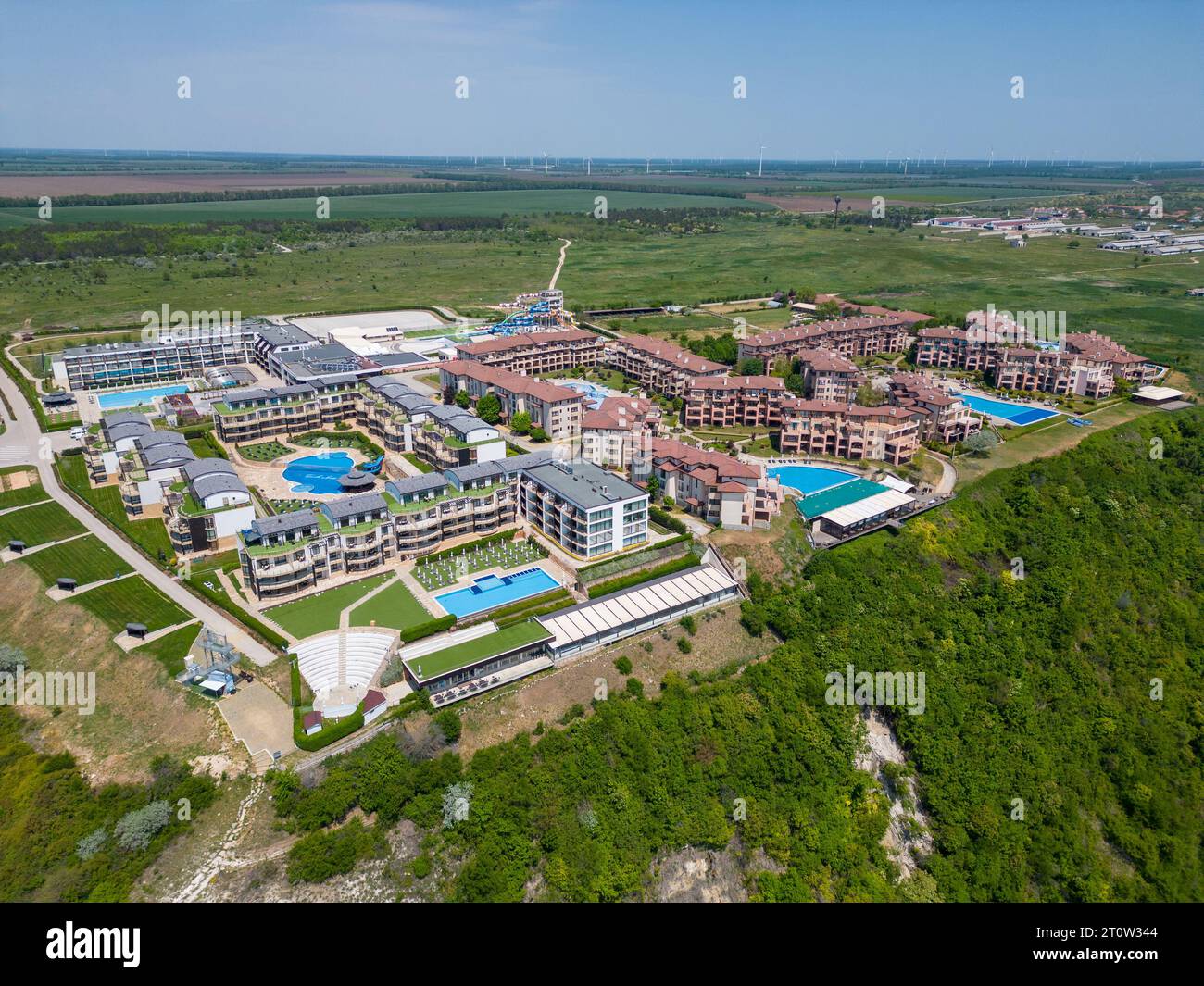 The massive modern hotel complex sprawled beneath, boasting a myriad of swimming pools, sports fields, and recreation areas. From above, the vibrant o Stock Photo