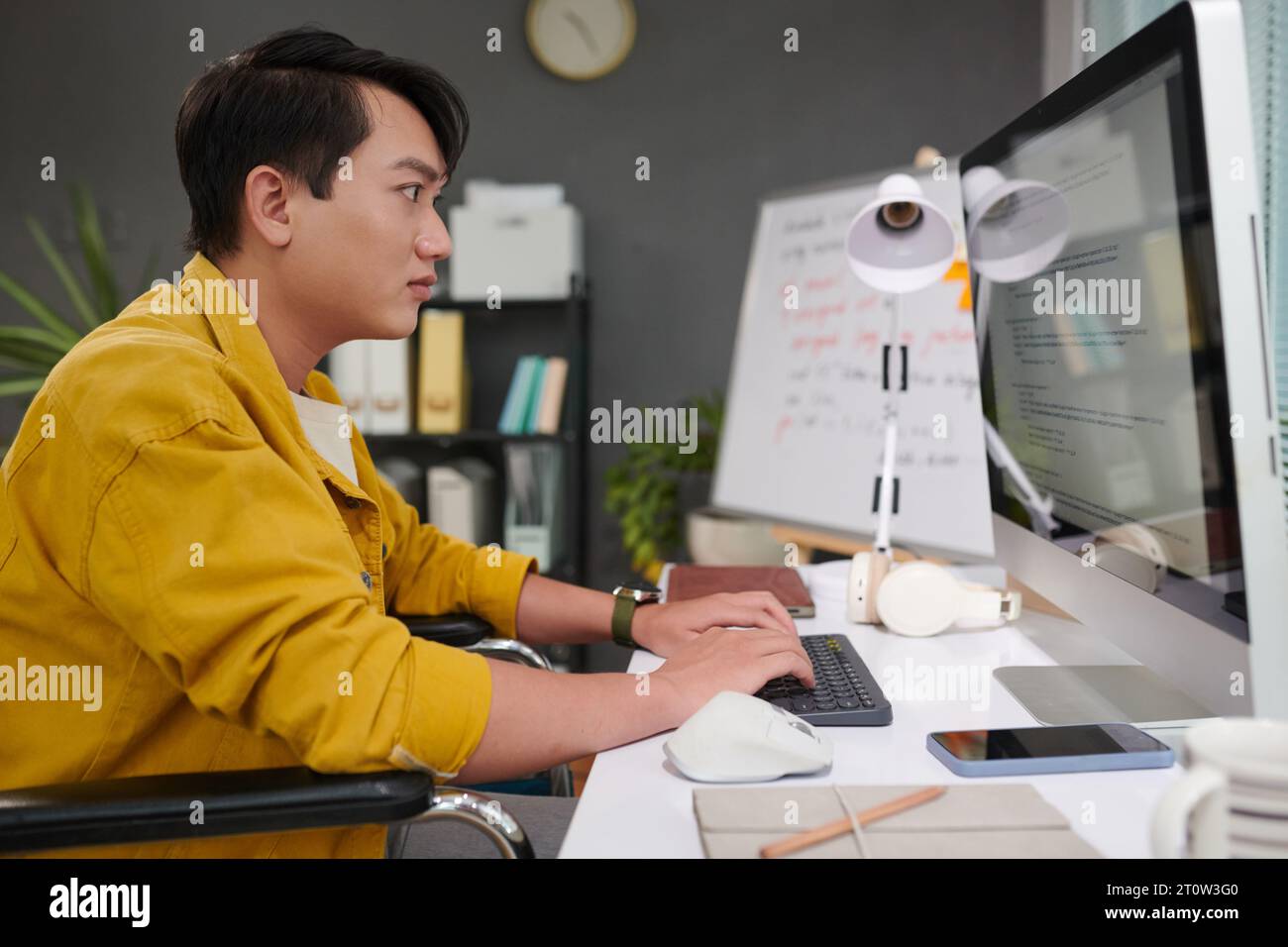Young man with disability working as software developer Stock Photo