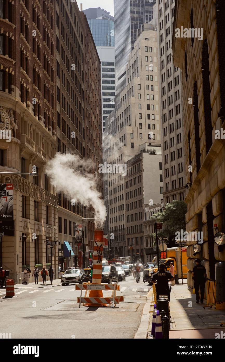 NEW YORK, USA - NOVEMBER 26, 2022: busy avenue with traffic, pedestrians and steam pipe in downtown Stock Photo