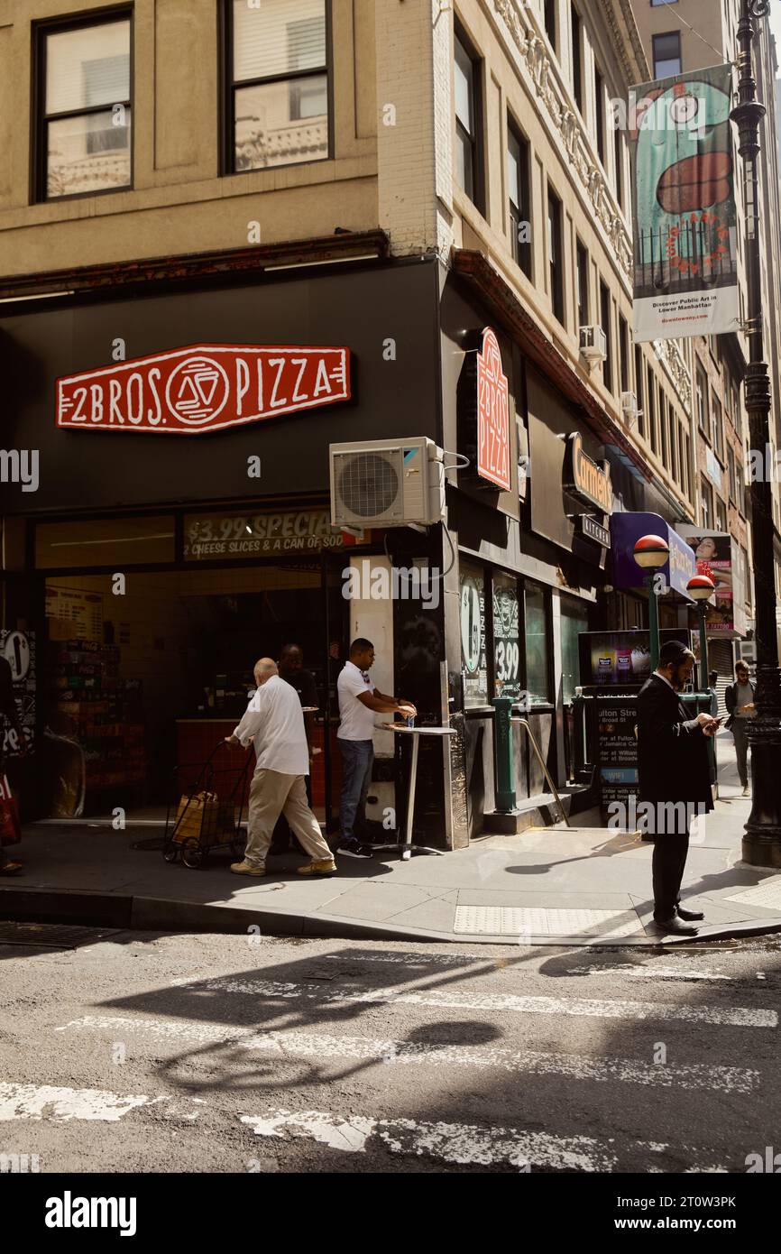 NEW YORK, USA - NOVEMBER 26, 2022: 2bros pizza house and pedestrians on sidewalk in downtown Stock Photo