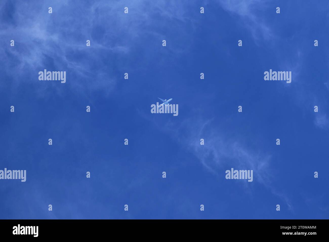 Airplane in the blue sky with white clouds Stock Photo - Alamy