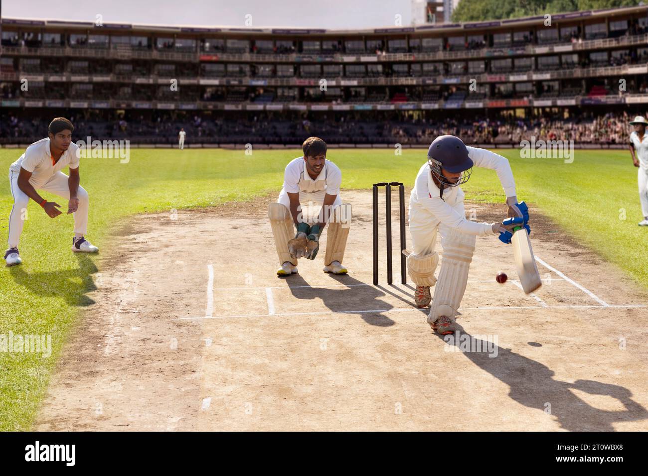 Batsman hitting the ball on the leg side while playing a cricket match Stock Photo