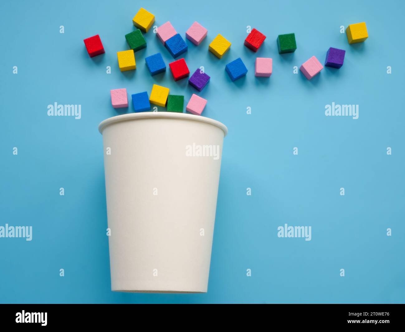 A paper cup and colorful cubes as a symbol of positivity and creativity. Minimal. Modern trendy art. Stock Photo