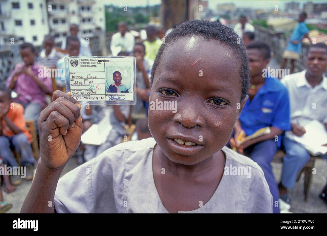 Liberia, Monrovia; portrait of an ex child soldier showing his school pass. Stock Photo
