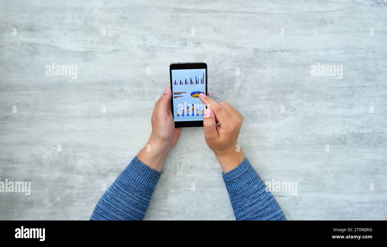 Trading Number Code Using Hands Top view of businessman hands using mobile phone with charts and data ...