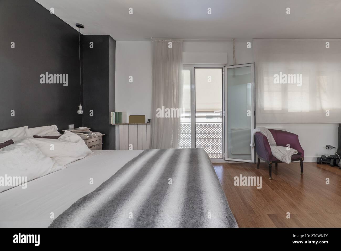Double bedroom en suite with balcony with views, walls in two colors, wooden floors Stock Photo