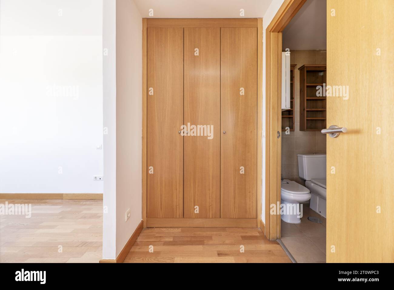Walk-in wardrobe with light wooden doors Stock Photo