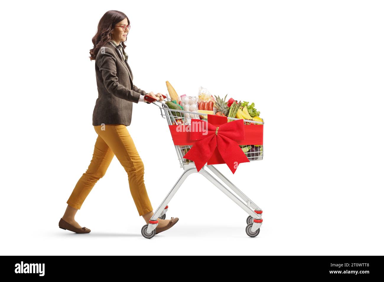 Full length profile shot of a young woman walking with a shopping cart