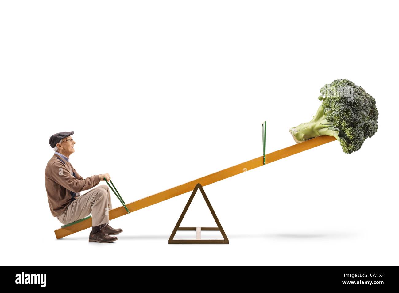 Full length profile shot of an elderly man and a broccoli on a seesaw isolated on white background Stock Photo