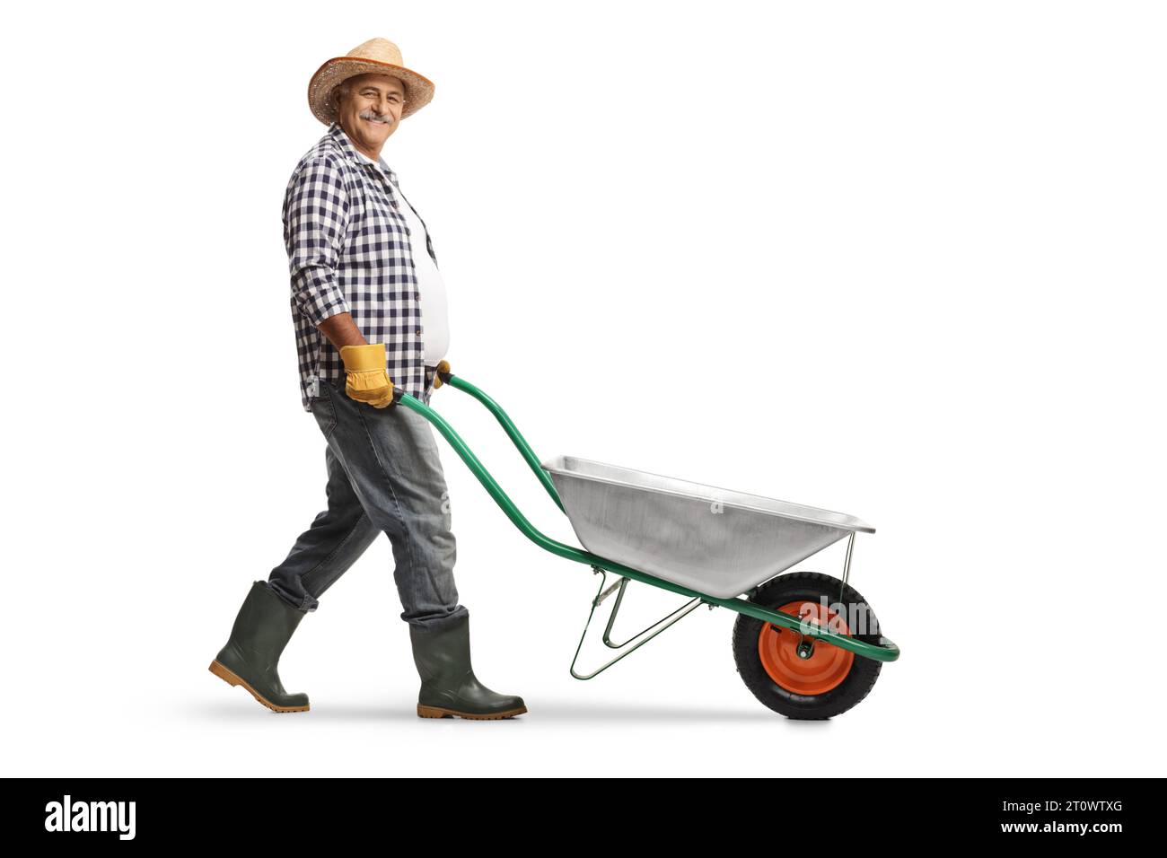 Full length profile shot of a mature male gardener pushing a wheelbarrow isolated on white background Stock Photo