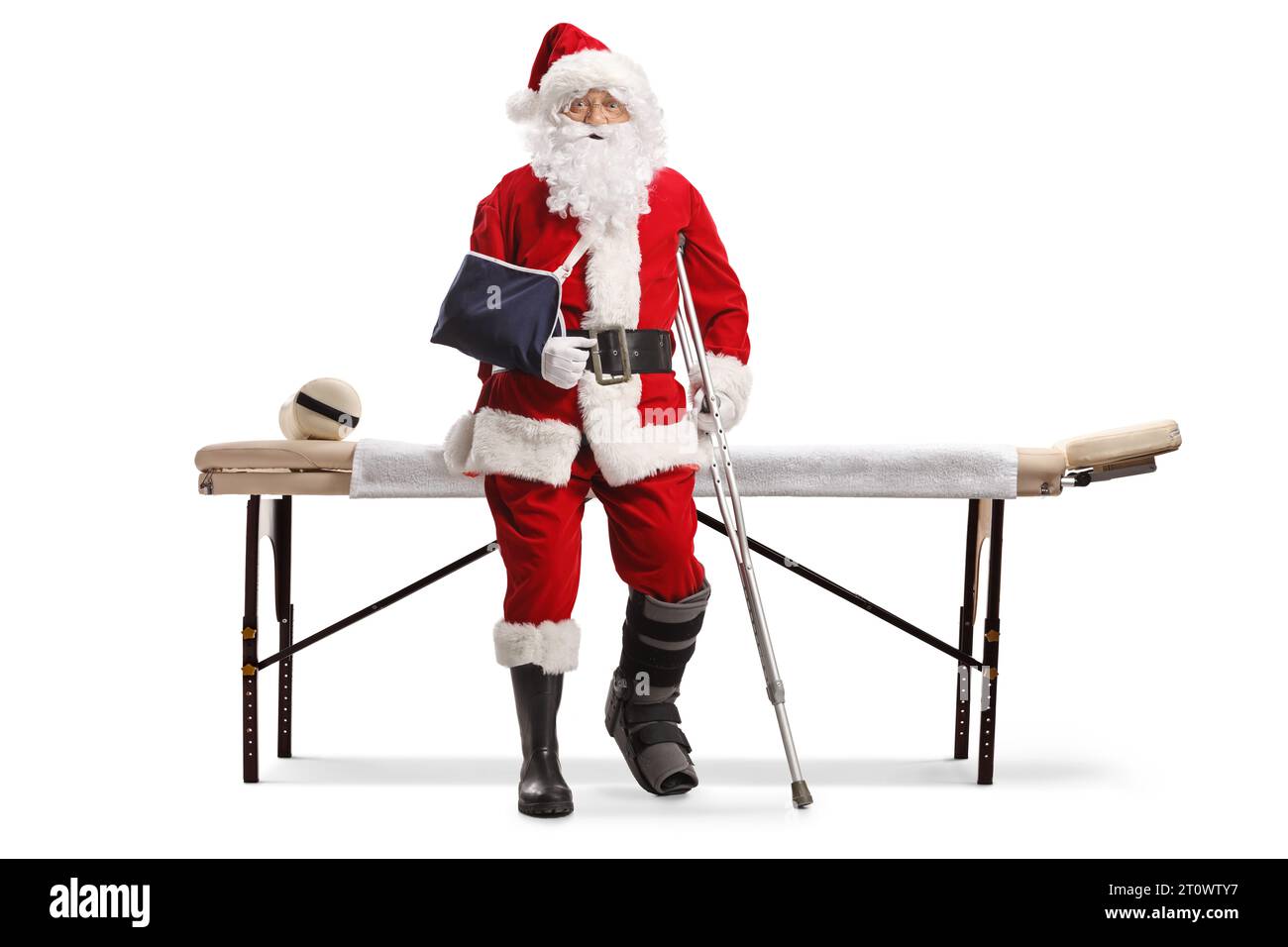 Santa claus with injured leg and arm standing in front of a mat table isolated on white background Stock Photo