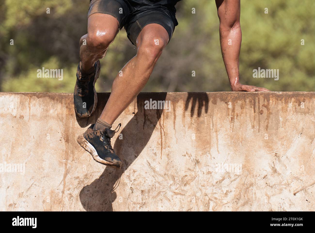 Mud race runners running over obstacles extreme sport Stock Photo