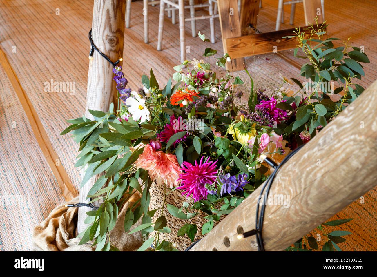 Wedding flowers in a marquee. Tables, chairs, flowers and place settings. A rustic teepee design of tent. Stock Photo