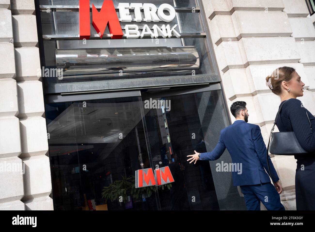 A man exits the Piccadilly branch of Metro Bank on Piccadilly and holds the door, on 9th October 2023, in London, England. Metro Bank is launching a fresh cost-cutting drive after the lender secured a £925m rescue package from investors over the weekend. Metro was the UK’s first new high street lender in 150 years when it first opened in 2010. It has confirmed overnight that customers had started to pull their money out in recent days amid worries over its financial health. Stock Photo