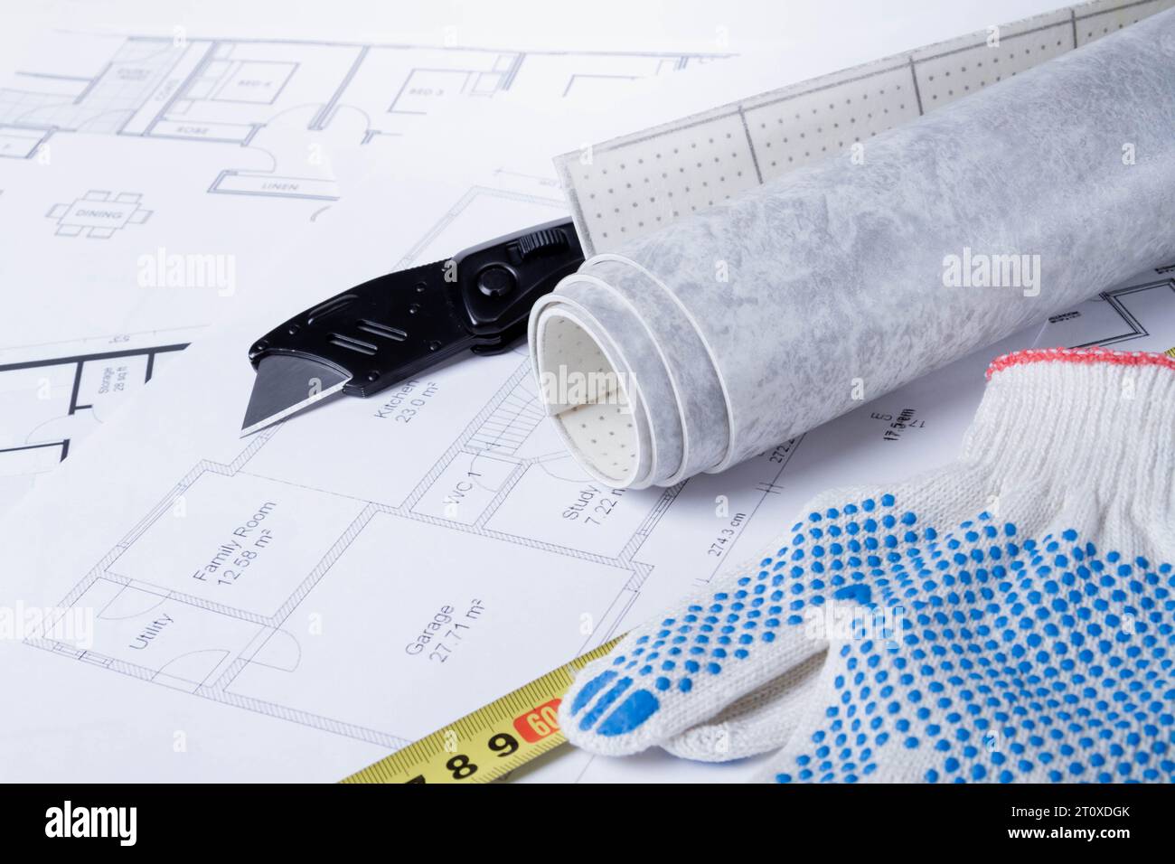 Laying flooring. Linoleum, a knife and a house plan on the builder's