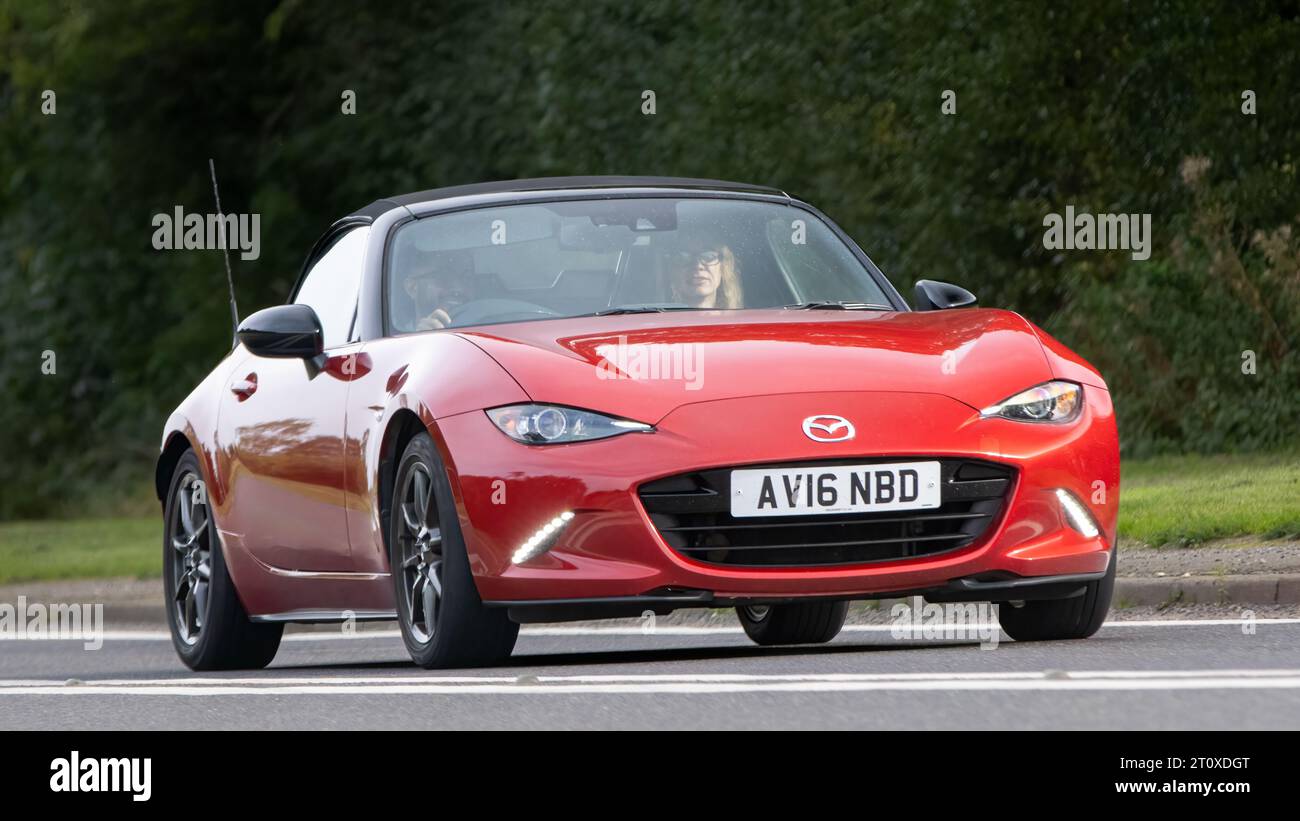 Bicester,Oxon.,UK - Oct 8th 2023: 2016 red mazda MX5 classic car driving on an English country road. Stock Photo