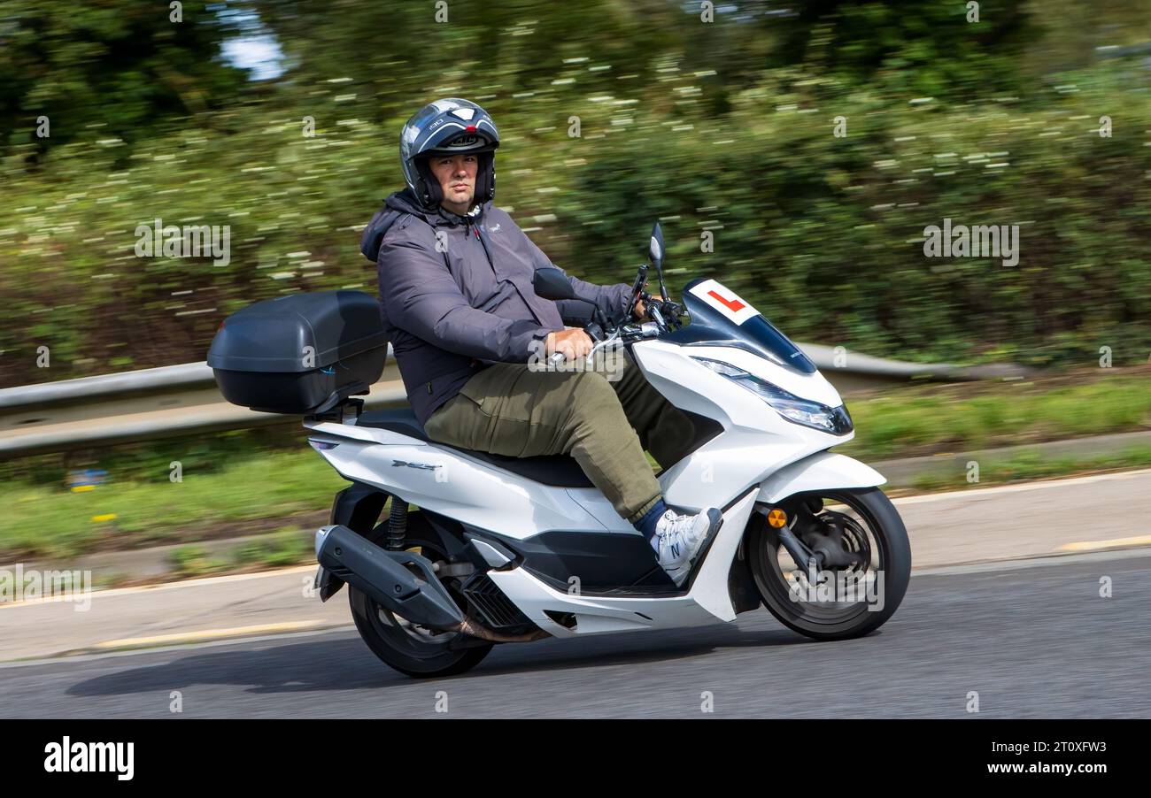 Milton Keynes,UK Sept. 21st 2023Man riding a white Honda PCX scooter