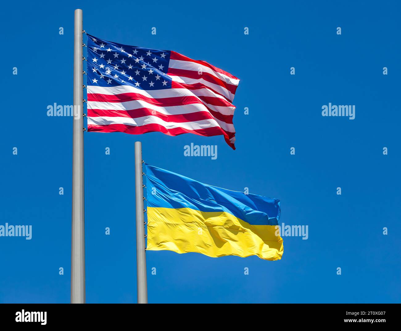 flags of United States and Ukraine waving in the wind against blue sky ...