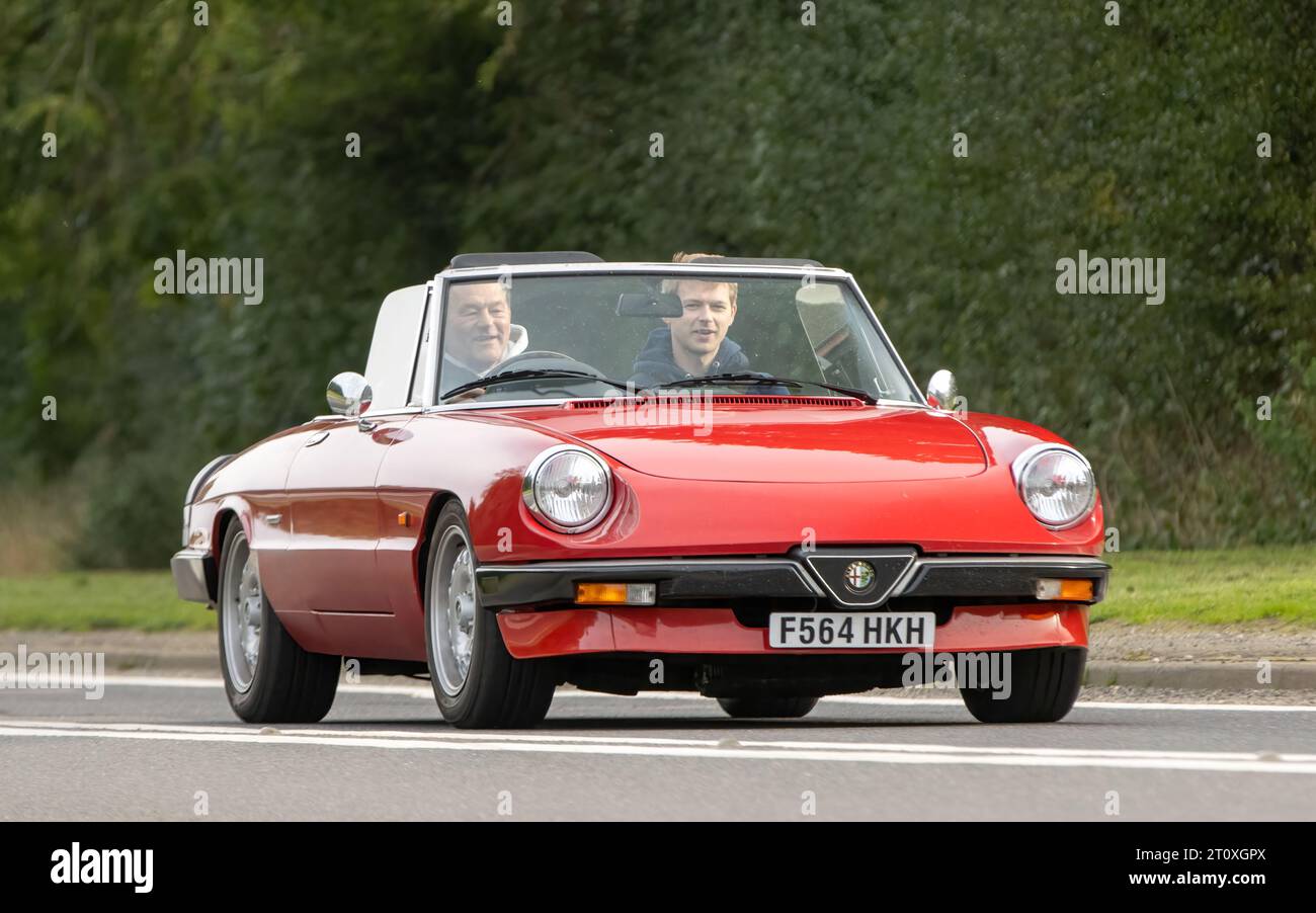 Bicester,Oxon.,UK - Oct 8th 2023: 1989 red Alfa Romeo Spider classic car driving on an English country road. Stock Photo