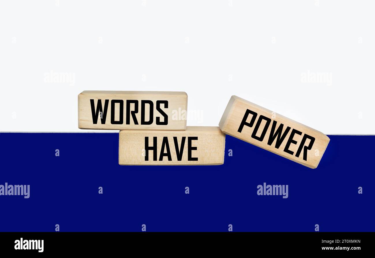 Words have power written on a wooden block and a white and blue photo. Stock Photo