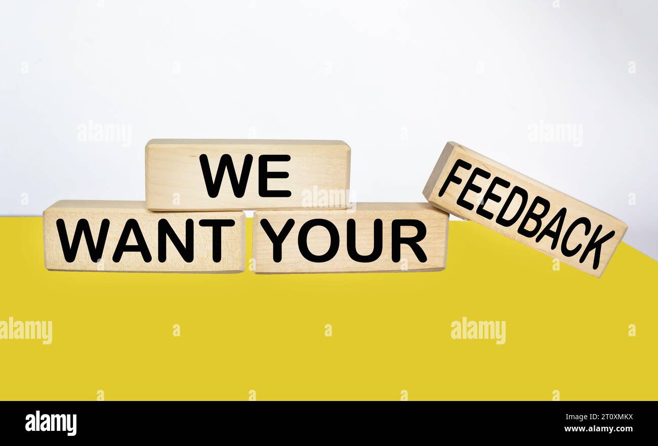 We need your feedback text on wooden block and yellow and white background Stock Photo