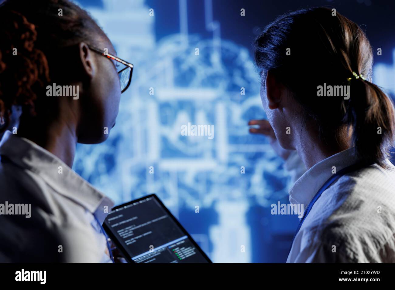 IT consultants brainstorm ways to use AI cognitive computing to extract usable information from complex data. High tech facility workers implement artificial intelligence to process inference datasets Stock Photo