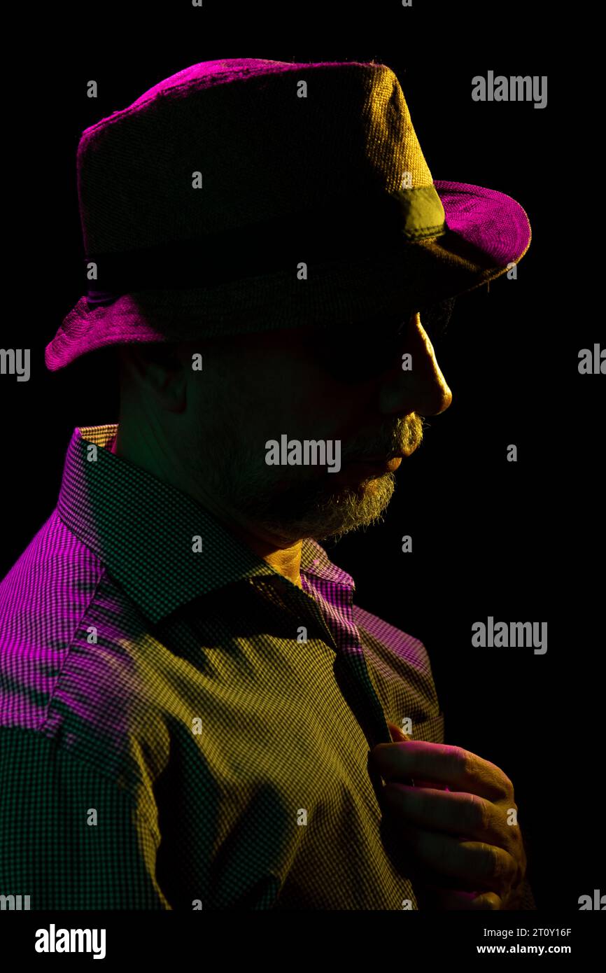 Mysterious man wearing hat and sunglasses. Portrait in dark studio ...