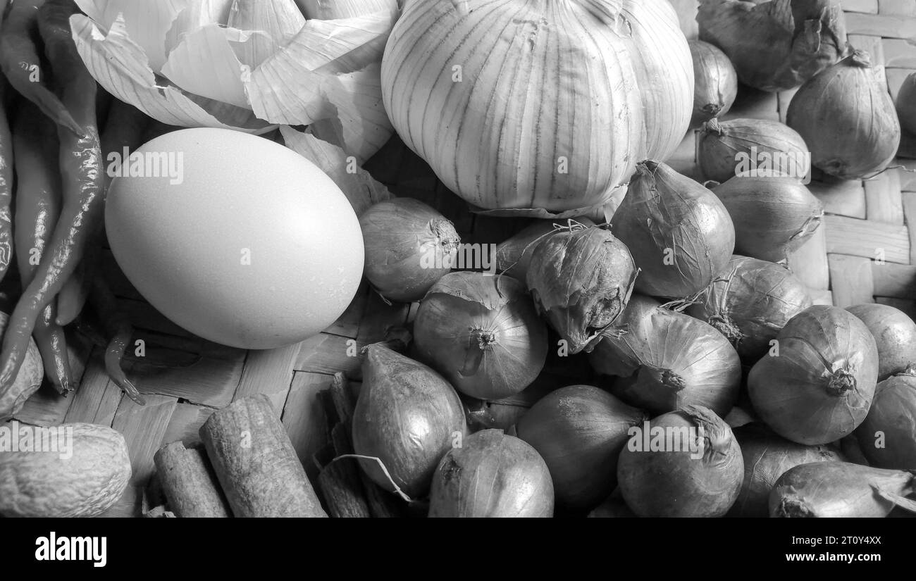 Photo of spices in the form of shallots, garlic, chilies and eggs arranged in a woven bamboo Stock Photo