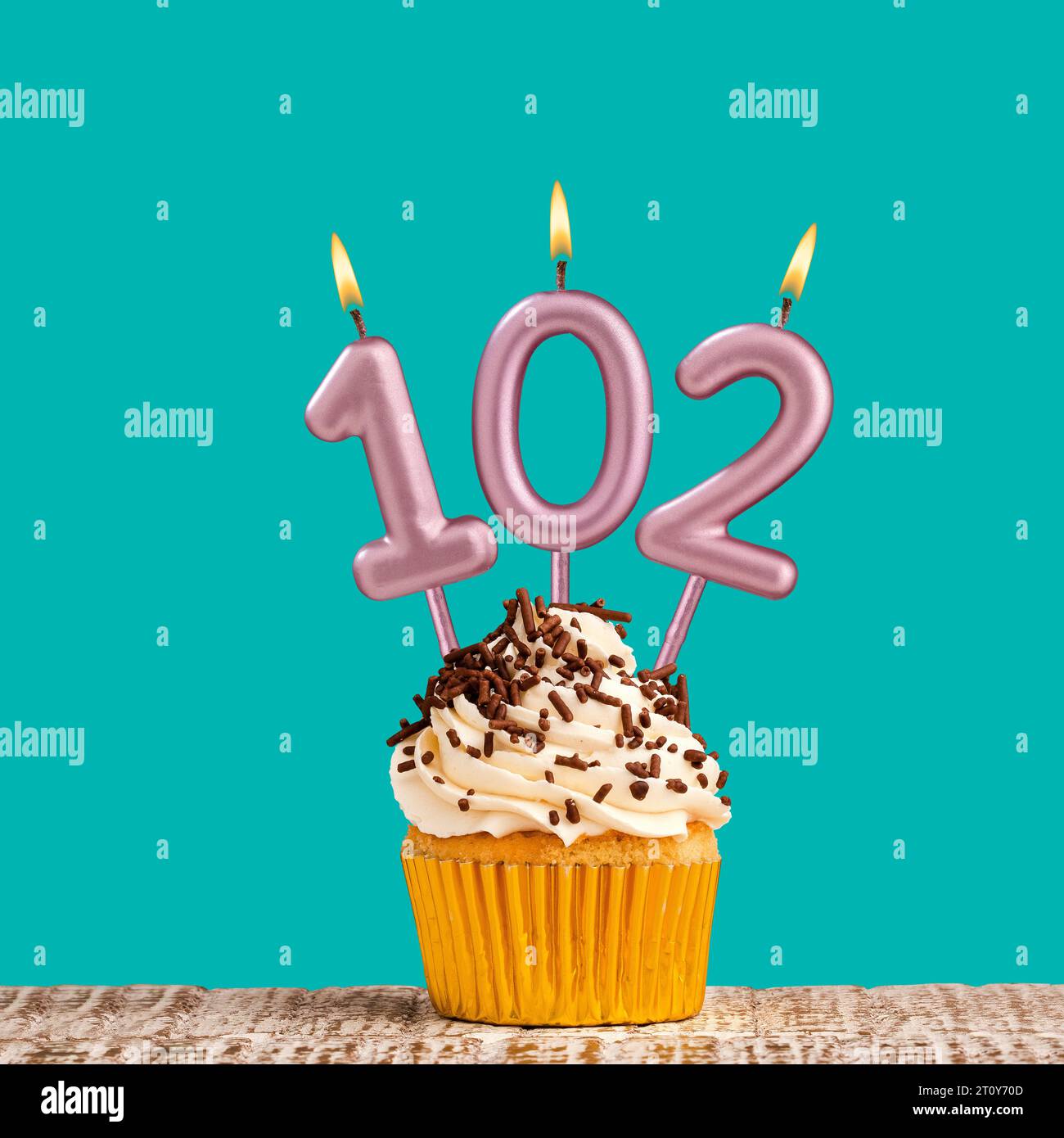 Cupcake with sparkling candle for 39th birthday or anniversary with big  number in white with yellow streamers on blue table with dark background  full Stock Photo - Alamy