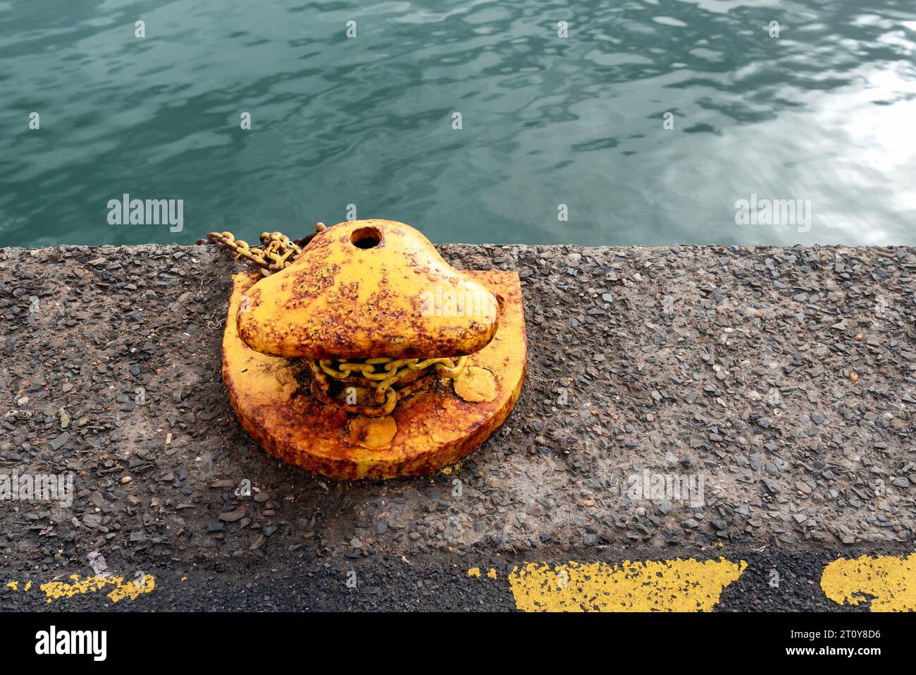 Yellow rusty mooring pole Stock Photo