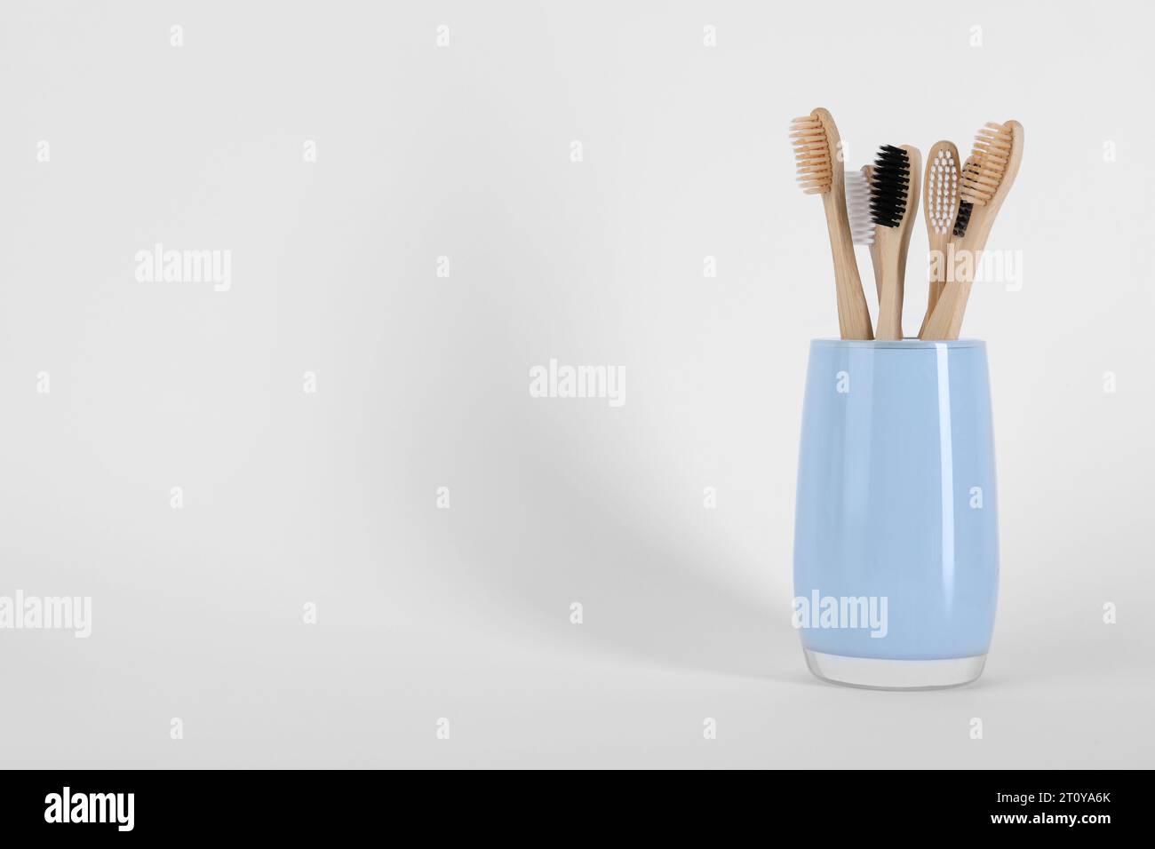 Bamboo toothbrushes in holder on white background, space for text Stock ...