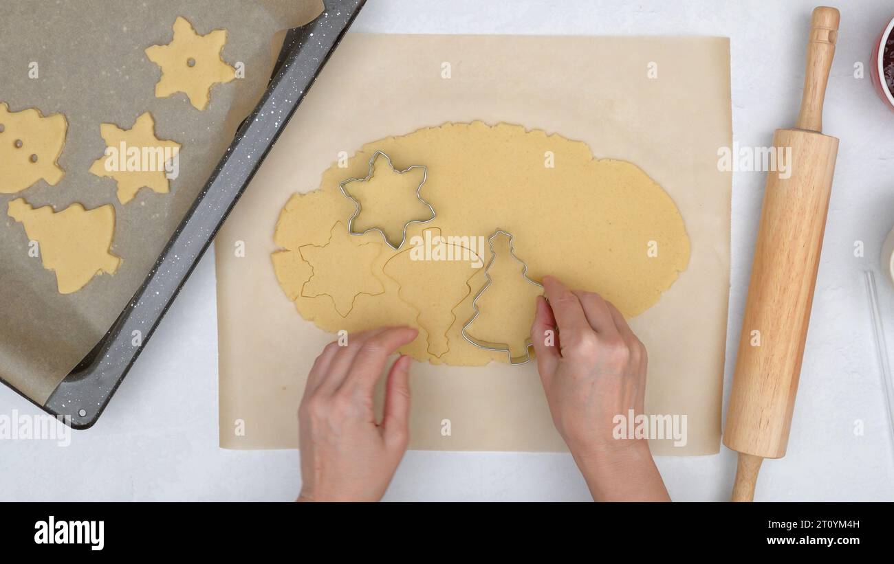 Woman hands making stamps on cookie dough. Step by step Christmas shortbread cookie recipe, close up baking process Stock Photo