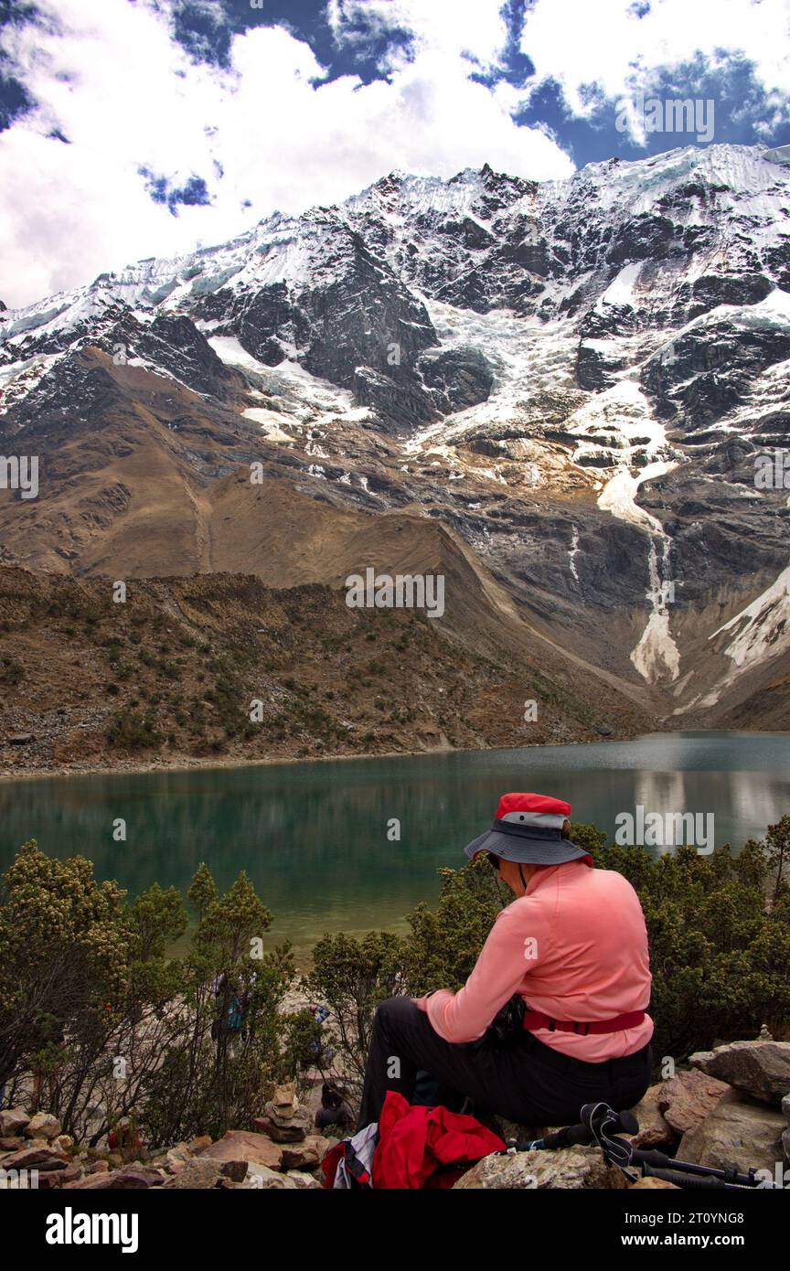 Rear view of senior woman sitting on Humantay lake in Peru Stock Photo