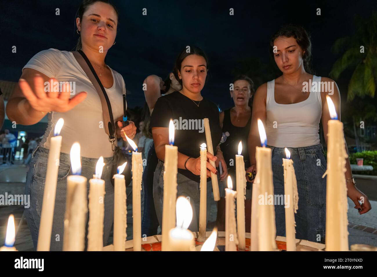 Aventura, Florida, USA. 9th Oct, 2023. Young women light candles and