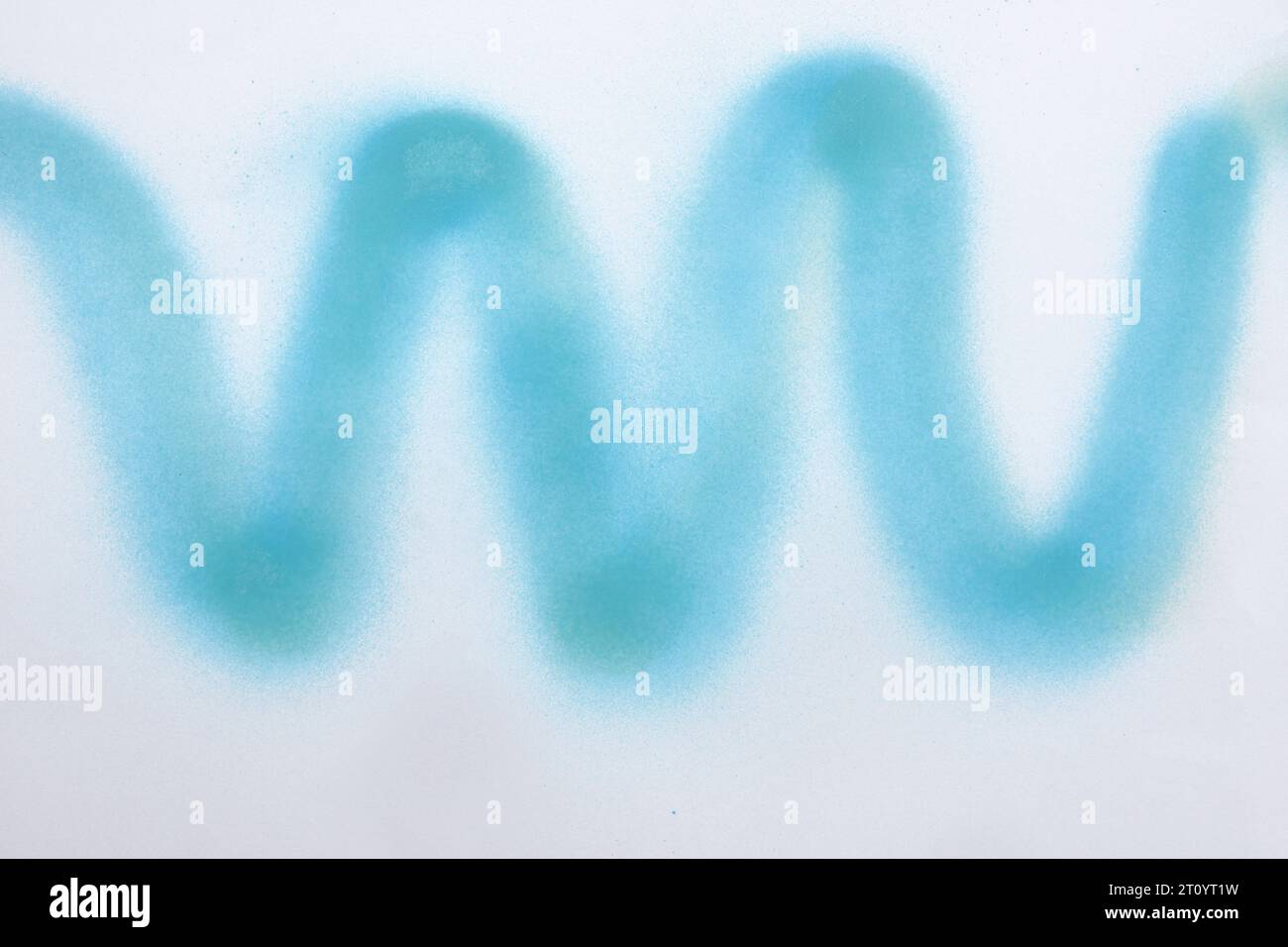 wavy line of blue spray paint on white paper background Stock Photo