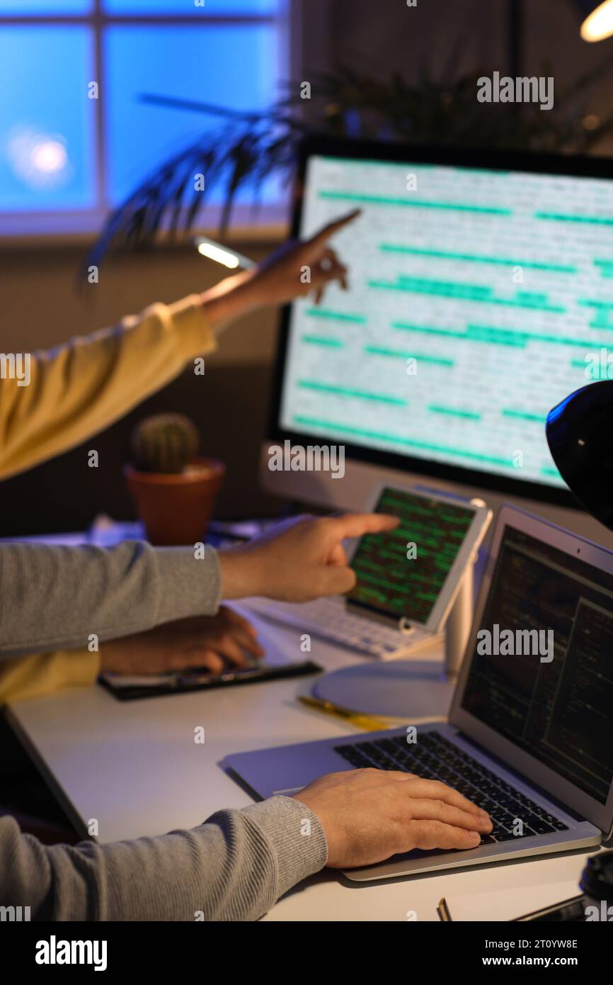 Programmers working in office at night, closeup Stock Photo