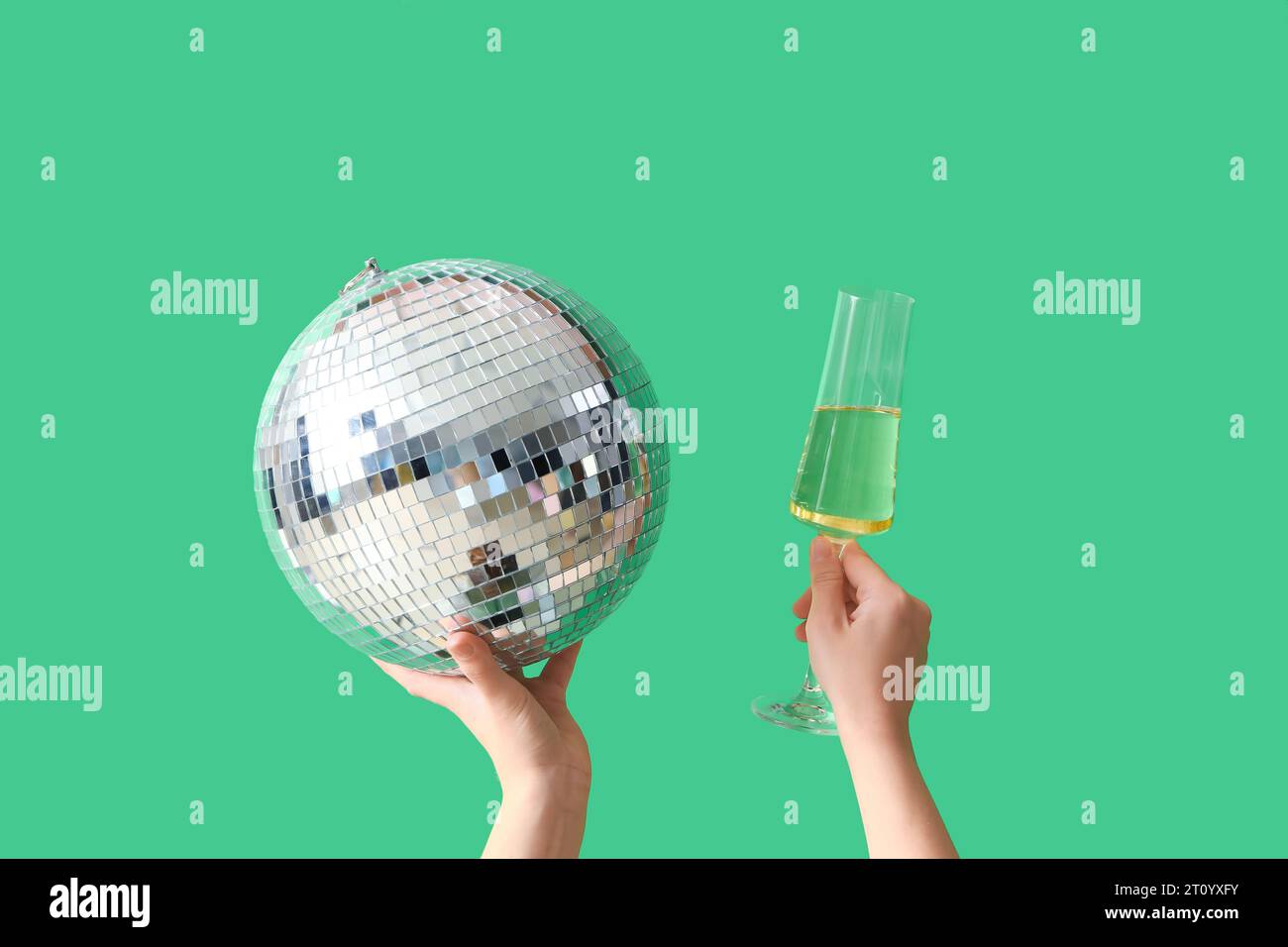 Female hands with glass of champagne and disco ball on green background.  Birthday celebration Stock Photo - Alamy