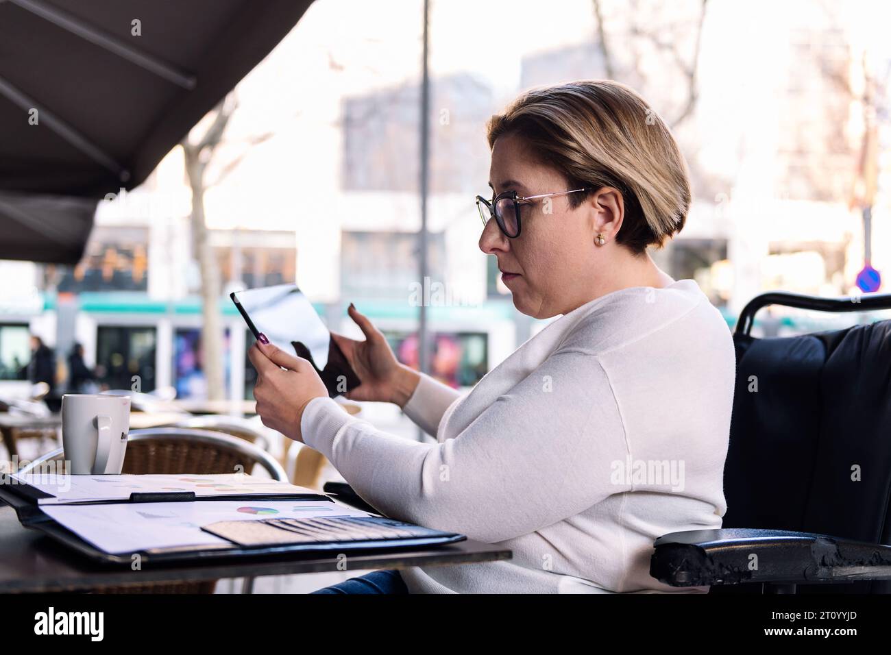 woman using wheelchair working with a tablet Stock Photo