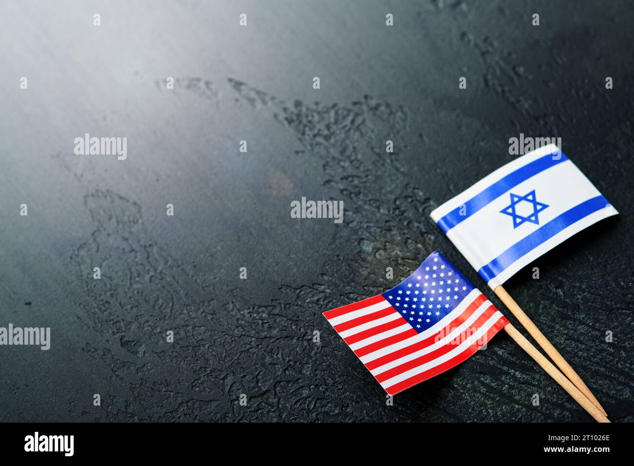 USA Israel flags. Two small American and Israeli flags lie on black old texture background opposite each other conveys partnership between two states Stock Photo