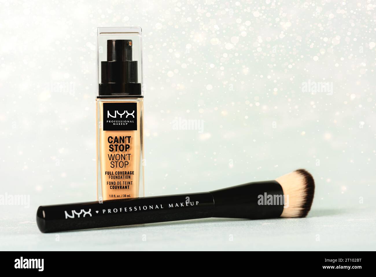 Makeup foundation bottle Can'stop won'stop Full coverage foundation NYX professional makeup and makeup brush over light background. NYX professional m Stock Photo