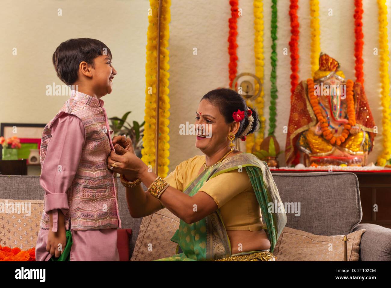 Grandmother getting her grandson ready on the occasion of Ganesh Chaturthi Stock Photo