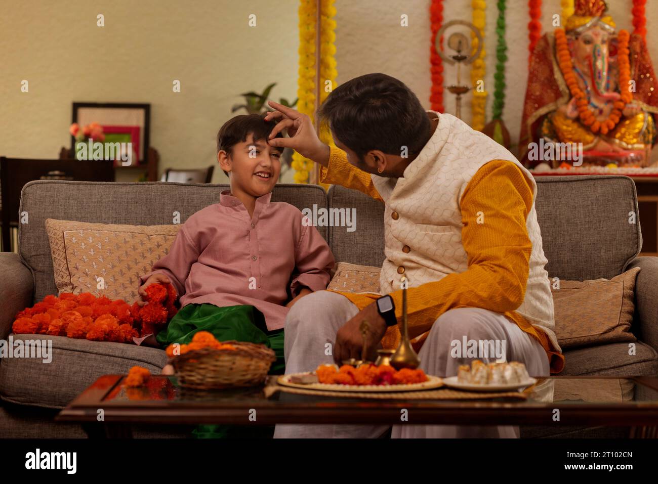 Father applying tilaka to forehead of his son on the occasion of Ganesh Chaturthi Stock Photo