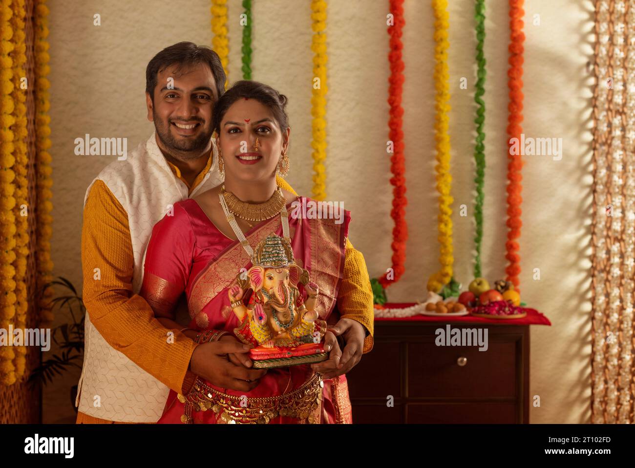 Portrait of happy young couple holding an idol of Lord Ganesha Stock Photo